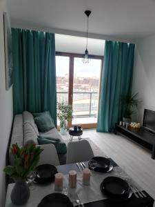 ein Wohnzimmer mit einem Sofa und einem Tisch in der Unterkunft AL Mare Apartament in Danzig