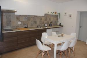 kuchnia z białym stołem i białymi krzesłami w obiekcie Quinta do Sr. Cabrita w Albufeirze