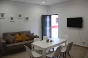 een woonkamer met een witte tafel en een bank bij Quinta do Sr. Cabrita in Albufeira