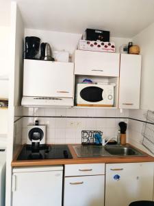 a kitchen with white cabinets and a microwave at Appartement d'une chambre avec balcon a Cauterets in Cauterets