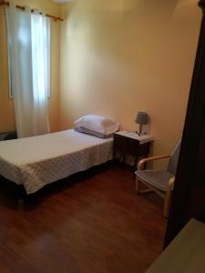 a small bedroom with a bed and a chair at Cc39-Q6 in Funchal