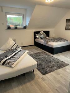 a bedroom with two beds and a rug at Ferienhaus Mone in Mayen