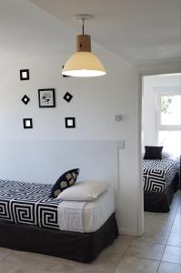 a bedroom with two beds and a light fixture and a bed sqor at Bariloche Apartment in San Carlos de Bariloche