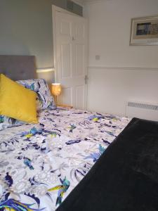 a bed with a comforter on it in a room at lovely 1 bedroom borders cottage in Town Yetholm
