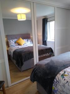 a bedroom with two beds and a mirror at lovely 1 bedroom borders cottage in Town Yetholm