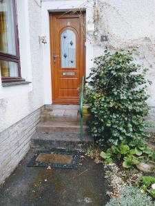 a wooden door on a house with a plant at lovely 1 bedroom borders cottage in Town Yetholm