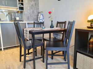 a dining room table with four chairs and a kitchen at Azyl Puck in Puck