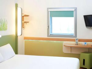 
a bathroom with a sink, mirror and a television at ibis budget Newport in Newport
