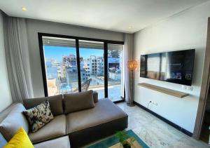 a living room with a couch and a large window at Amazing Flat in Gauthier - Breathtaking View - Best Location in Casablanca