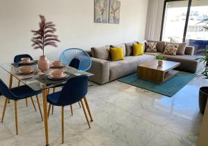 a living room with a couch and a table and chairs at Amazing Flat in Gauthier - Breathtaking View - Best Location in Casablanca