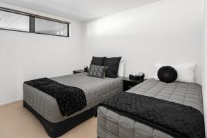 een slaapkamer met 2 bedden en een raam bij Luxury Waterfront Apartment - Abode No 1 in Picton