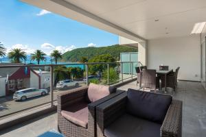 a balcony with a couch and a table with a view at Luxury Waterfront Apartment - Abode No 1 in Picton