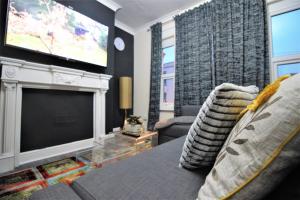 uma sala de estar com um sofá e uma televisão de ecrã plano em Quantock Lodge Studio 2 em Strood