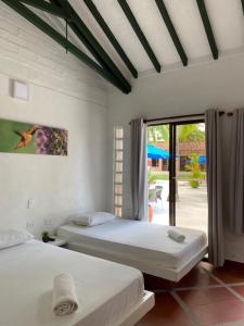 two beds in a bedroom with a view of a patio at La Manola Finca Hotel in Doradal +132 photos