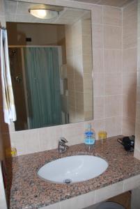 a bathroom counter with a sink and a mirror at Hotel Conchiglia in Montecatini Terme