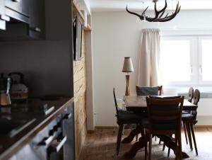 安德馬特的住宿－安德馬特瑞士木屋酒店，厨房以及带桌椅的用餐室。
