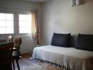 Un dormitorio con una cama con almohadas azules y una ventana en Chalet Swiss Andermatt, en Andermatt