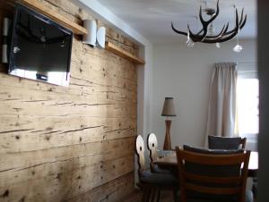 a living room with a wooden wall with a tv on it at Chalet Swiss Andermatt in Andermatt