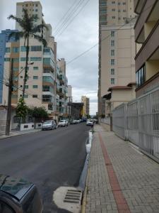 a city street with cars parked on the side of the road at Novo Lar Itapema-2 in Itapema