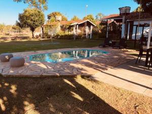 a swimming pool in a yard with a house at Pousada Jardim da Chapada in Chapada dos Guimarães