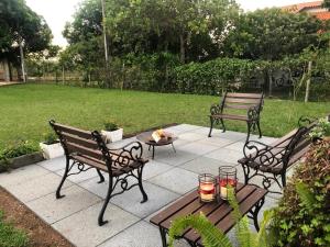 zwei Bänke und ein Tisch mit Kerzen auf einer Terrasse in der Unterkunft Pousada Jardim da Chapada in Chapada dos Guimarães