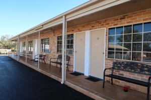 a brick building with benches on the side of it at Charleville Waltzing Matilda Motor Inn in Charleville