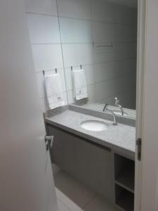 a bathroom with a sink and a mirror at LAGUNA BEACH FLAT EM PORTO in Porto De Galinhas