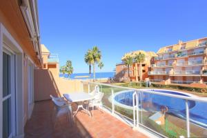einen Balkon mit einem Tisch, Stühlen und einem Pool in der Unterkunft Apartamento Mirador al Mar in Denia