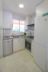 een keuken met witte apparatuur en een witte koelkast bij Apartamento Mirador al Mar in Denia