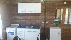 cocina con fogones, fregadero y pared de ladrillo en Cabaña: LOS ABUELOS, en San Rafael