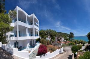 ein weißes Haus mit Blick auf das Meer in der Unterkunft Christine Studios in Poros