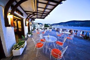 a patio area with chairs, tables and umbrellas at Mirini Hotel in Samos