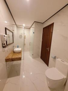 a bathroom with a toilet and a sink and a shower at Kingdom Hotel Cua Lo in Cửa Lô