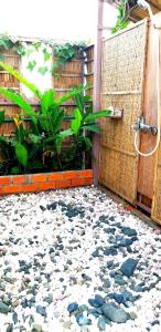 a garden with a rock floor in front of a shower at Việt Mekong Farmstay in Tràm Chim