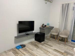 sala de estar con TV de pantalla plana en la pared en Memories Homestay, en Xincheng