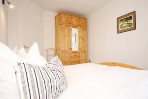 キュールングスボルンにあるSonnenresidenz-Wohnung-2-640の白いベッドと木製キャビネット付きのベッドルーム1室が備わります。