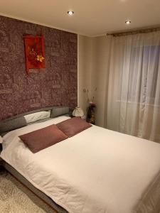 Schlafzimmer mit einem großen weißen Bett und einer roten Wand in der Unterkunft Apartment in Daugavpils Centre in Daugavpils