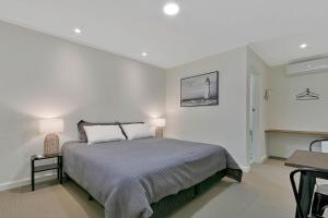 a white bedroom with a bed and a table at Lyndoch Hotel in Lyndoch