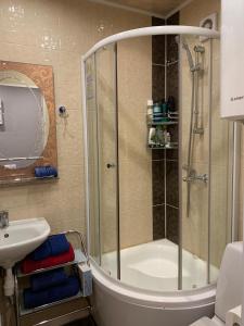 ein Bad mit einer Dusche und einem Waschbecken in der Unterkunft Apartment in Daugavpils Centre in Daugavpils