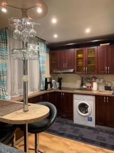 a kitchen with a table and a washing machine at Apartment in Daugavpils Centre in Daugavpils