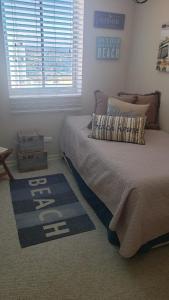 a bedroom with a bed with a blue rug and a window at Departamento Laguna Bahia, Algarrobo in Algarrobo