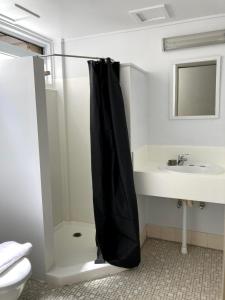 a bathroom with a shower with a black shower curtain at Cairns City Motel in Cairns