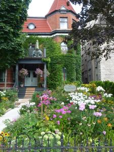 uma casa com um jardim de flores em frente em Auberge King Edward Bed and Breakfast em Ottawa