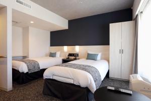 Postel nebo postele na pokoji v ubytování AkishimaStationHotel TOKYO