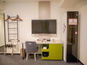 an office with a desk with a tv on a wall at Henn na Hotel Tokyo Ginza in Tokyo