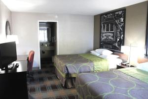 a hotel room with two beds and a flat screen tv at Super 8 by Wyndham Salinas in Salinas