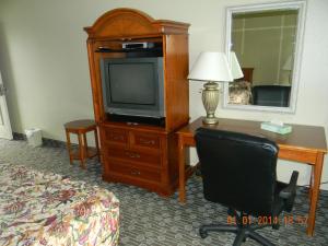 Habitación de hotel con escritorio, TV y silla en Lakeview Inn Centralia, en Centralia
