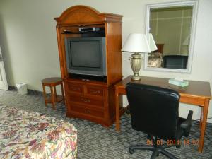 ein Hotelzimmer mit einem Schreibtisch, einem TV und einem Stuhl in der Unterkunft Lakeview Inn Centralia in Centralia