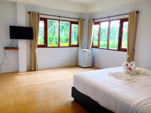 Un dormitorio con una cama con dos cisnes. en Oon Valley Farm Stay, en Ban Mae Pha Haen