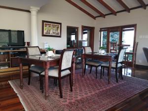 una sala da pranzo con tavoli, sedie e TV di Knysna Pearl View Guest House a Knysna